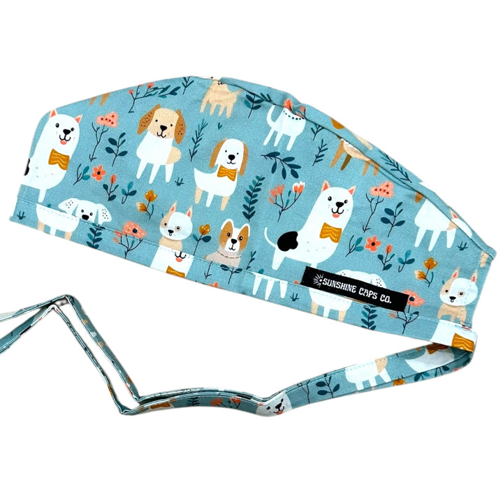 Blue scrub cap with dog pattern and visible brand label on a white background